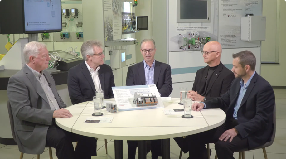 The image depicts a round table discussion featuring a group of professionals, with technical equipment and a backdrop suggesting a conference on industrial automation and SCADA systems.

AI-generated content may be incorrect.